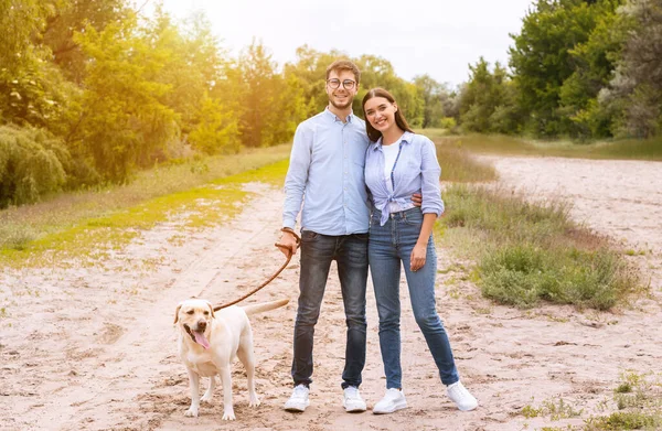 Tatlı bir çift ve av köpeği kırsalda birlikte yürüyorlar. — Stok fotoğraf