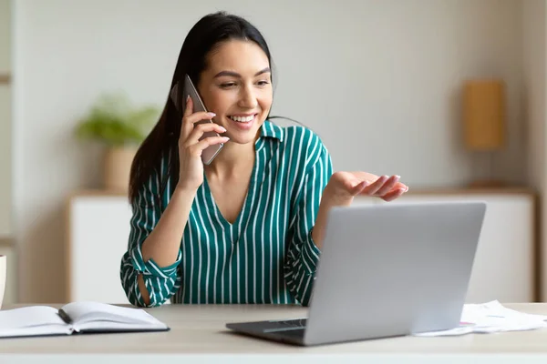 Business Lady μιλώντας στο τηλέφωνο κάθεται στο φορητό υπολογιστή στο γραφείο — Φωτογραφία Αρχείου