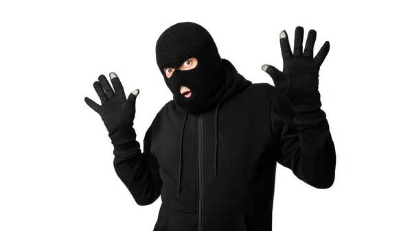 Beyaz duvara izole edilmiş kollarını kaldırmış tutuklu maskeli bir hırsız. — Stok fotoğraf