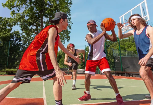 Diverse basketball team training for match at ourdoor sportsground