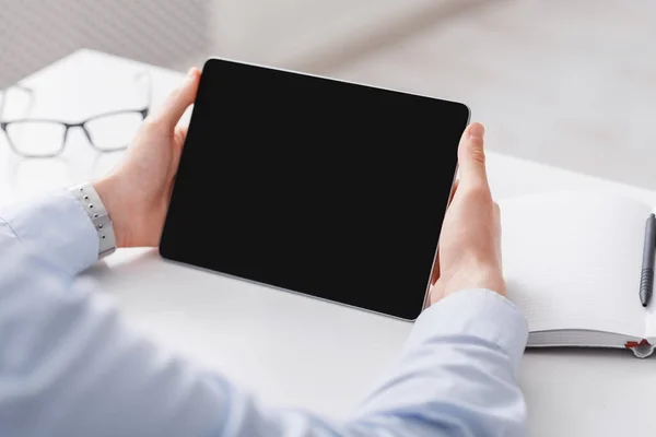 Pracovní plocha s tabletem a podnikateli ruce. Guy drží gadget s prázdnou obrazovkou pro online konzultaci — Stock fotografie