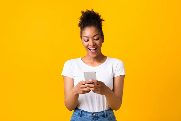 Sonriendo afro chica usando el teléfono celular en el estudio — Foto de Stock