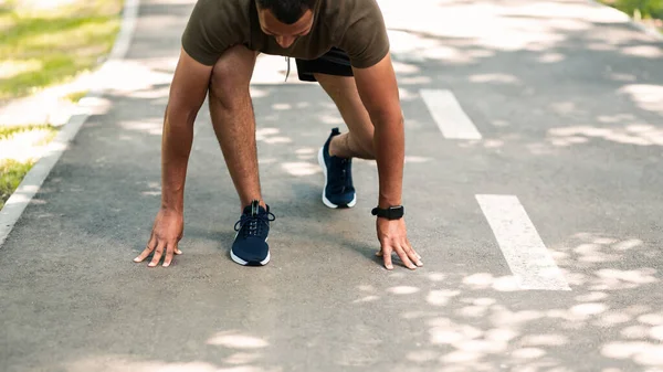 Ajuste o esportista afro-americano na posição inicial, pronto para correr na pista de jogging ao ar livre, copie o espaço — Fotografia de Stock