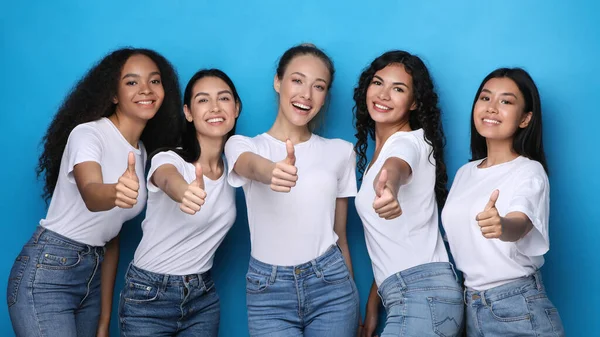 Cinque ragazze diverse gesturing Pollici su sorridente, sfondo blu, Panorama — Foto Stock