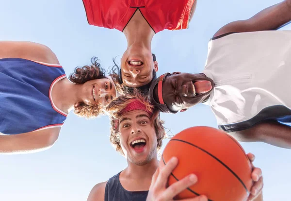 Pemain bola basket terbalik menyatukan kepala mereka dan membuat wajah konyol, bersenang-senang sebelum pertandingan. Tampilan bawah — Stok Foto