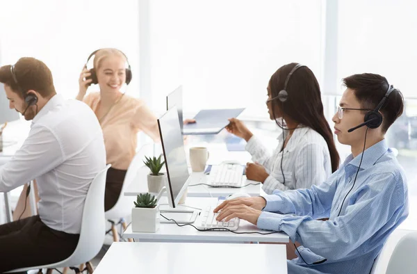 Equipe de agentes de suporte técnico trabalhando na linha direta no call center — Fotografia de Stock