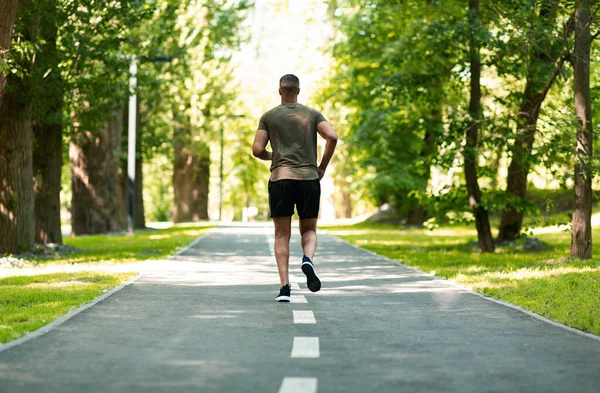 Joggerin läuft an Sommertag im grünen Park — Stockfoto