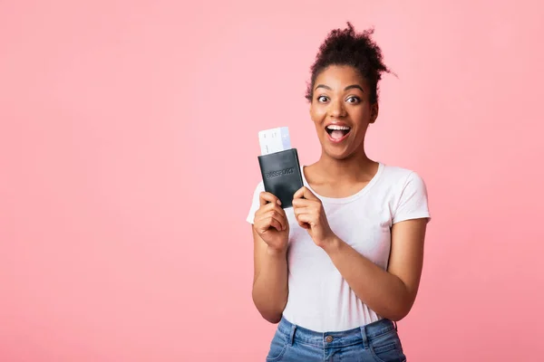 Mujer afro excitada sosteniendo boletos y pasaporte —  Fotos de Stock