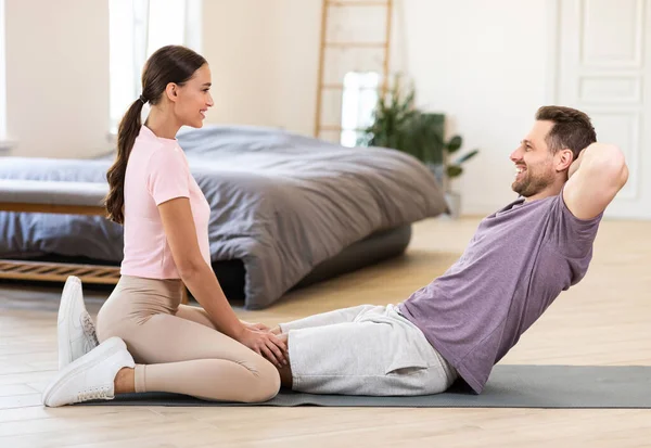 Deportiva pareja ejercitando entrenamiento juntos haciendo abdominales Sit-Ups en casa —  Fotos de Stock