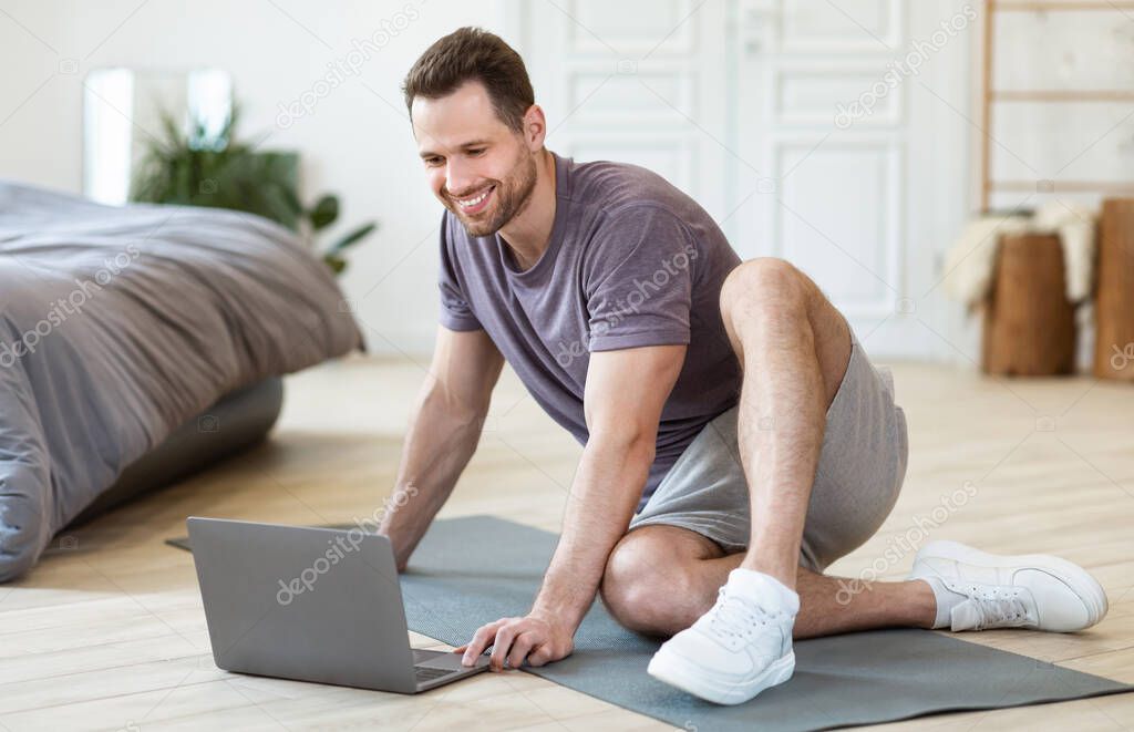 Man Turning On Laptop For Online Fitness Workout At Home
