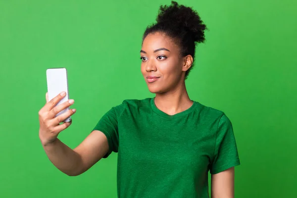 Yeşil stüdyoda cep telefonu kullanan mutlu siyah kız. — Stok fotoğraf