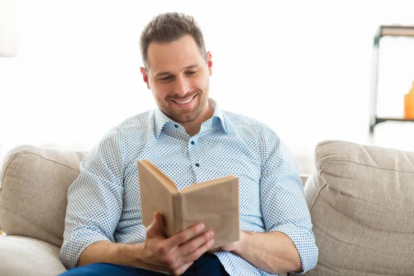 Evde kitap okuyan yakışıklı bir adam. — Stok fotoğraf
