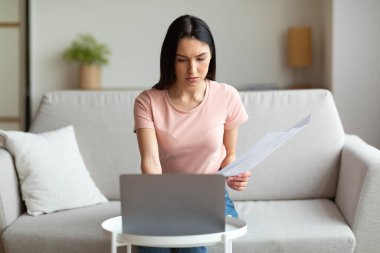 Ciddi Freelancer Kız laptopta çalışıyor, koltukta oturuyor.