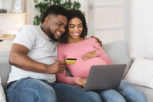 Usmívající se těhotná žena a její manžel nakupování online — Stock fotografie