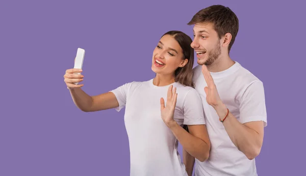 Felice giovane coppia utilizzando il telefono cellulare in studio — Foto Stock
