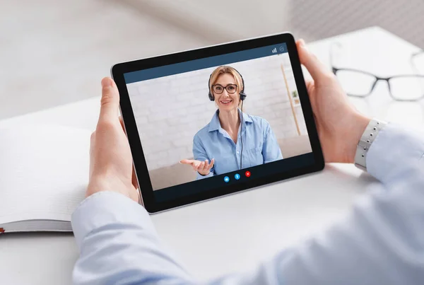 Lavoro online e comunicazione con il consulente. Uomo che tiene tablet con videochiamata della donna — Foto Stock