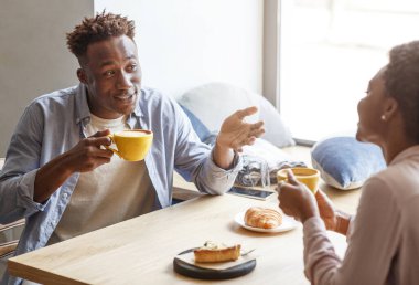 Güzel romantik çift birbirleriyle konuşuyor ve kafede kahve içiyorlar.