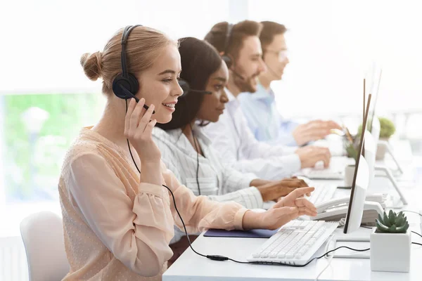 Equipo de operadores de línea de ayuda con auriculares que consultan a los clientes en la oficina del centro de llamadas, espacio vacío —  Fotos de Stock