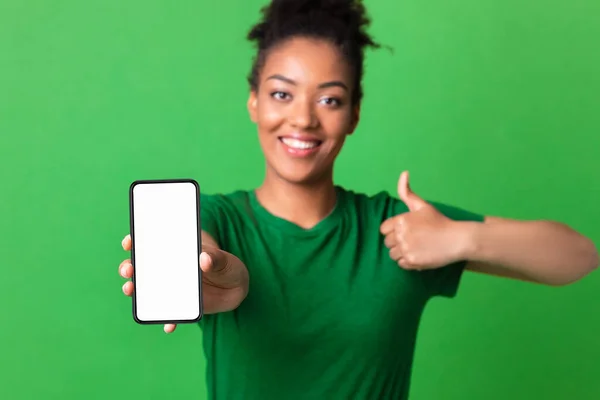 Chica africana mostrando blanco pantalla del teléfono celular en blanco en el estudio — Foto de Stock