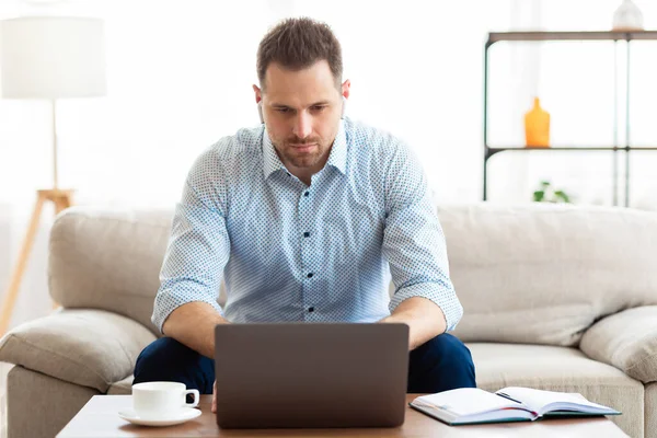 Kerel die online naar muziek luistert en laptop gebruikt — Stockfoto