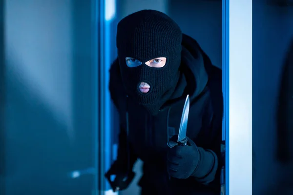 Criminal irrumpiendo en un apartamento con cuchillo — Foto de Stock