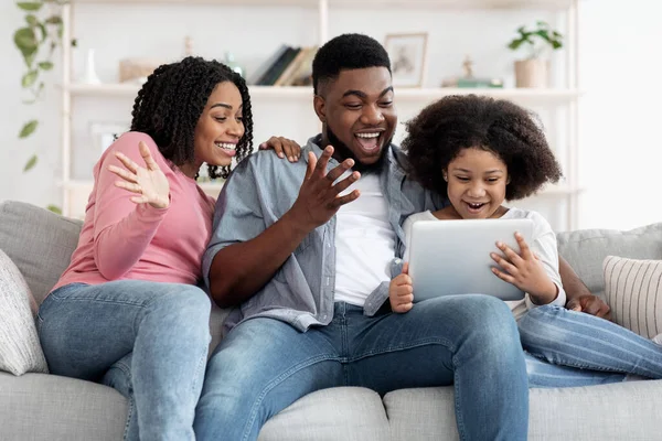 Família Africana alegre se divertindo com tablet digital em casa — Fotografia de Stock