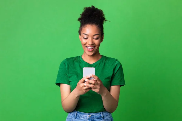 Χαμογελώντας afro κορίτσι χρησιμοποιώντας το κινητό τηλέφωνο στο στούντιο — Φωτογραφία Αρχείου