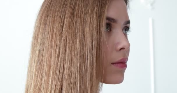 Профиль портрет молодой женщины, исправляющей волосы — стоковое видео