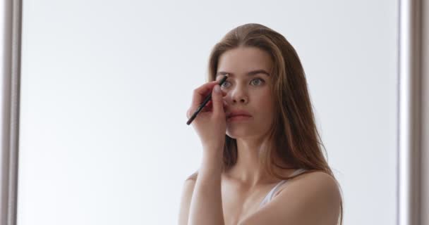 Joven hermosa mujer haciendo maquillaje con lápiz de cejas — Vídeo de stock