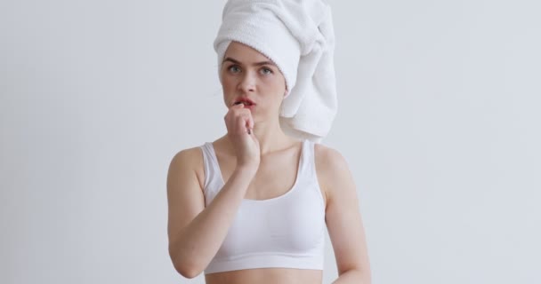 Menina jovem escovando os dentes após o chuveiro, com toalha na cabeça — Vídeo de Stock