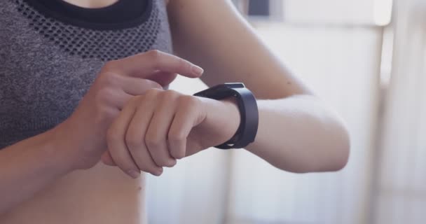 Mujer viendo sus resultados de entrenamiento intensivo en smartwatch — Vídeos de Stock