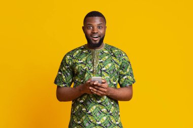 Modern cep telefonu tutan heyecanlı bir zenci.