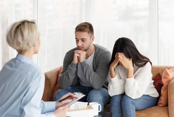Psicólogo profissional conversando com casal desesperado sentado no escritório — Fotografia de Stock