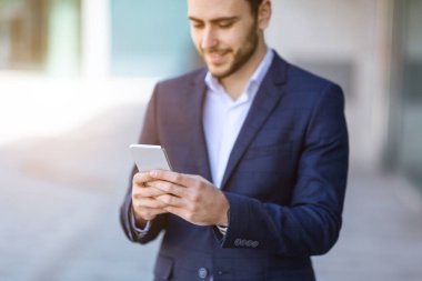 Milenyum iş temsilcisi şehir caddesinde cep telefonuyla iletişim kuruyor.