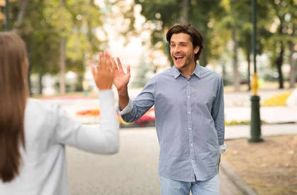Mann winkt mit Hallo-Geste und trifft Freundin beim Spazierengehen — Stockfoto