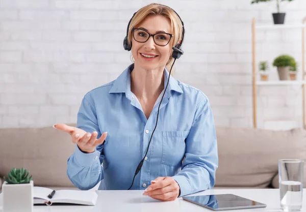 Consulta on-line de casa. Mulher em fones de ouvido com tablet estende a mão — Fotografia de Stock