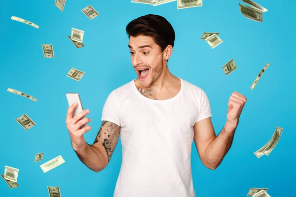 Lucky Winner. Emocionado hombre con Smartphone gritando con alegría bajo la ducha de dinero —  Fotos de Stock