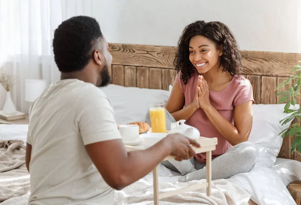 Marido surpreendente esposa com café da manhã na cama — Fotografia de Stock