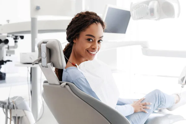 Mujer negra alegre sentada en silla de dentista — Foto de Stock