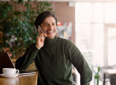 Zengin genç girişimci akıllı telefondan konuşuyor.