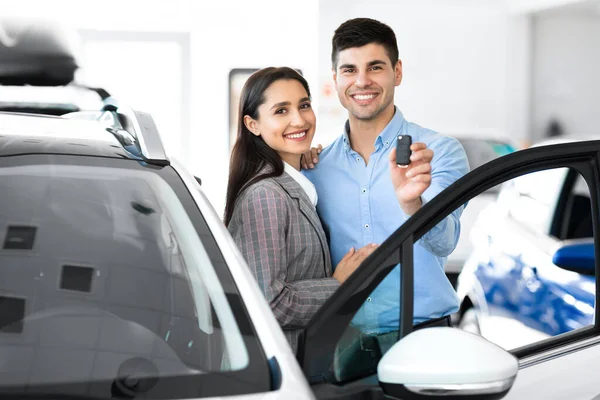 Familie toont auto sleutel knuffelen In Dealership — Stockfoto
