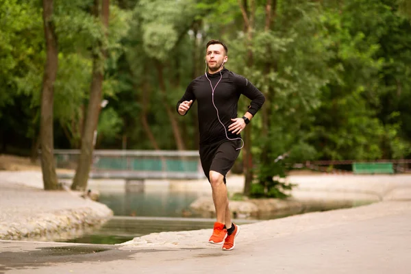 Retrato del chico trotando enfocado corriendo en el parque —  Fotos de Stock