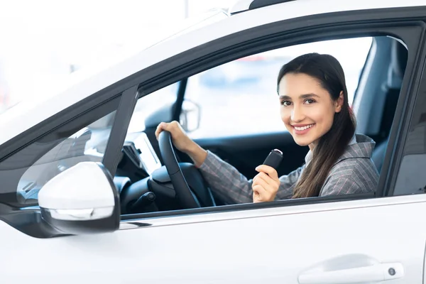 Freudige Frau zeigt Schlüssel im Fahrersitz — Stockfoto