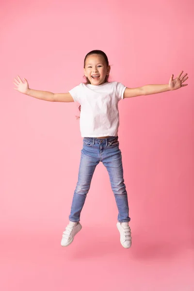 Feliz ásia menina saltando e olhando para câmara — Fotografia de Stock