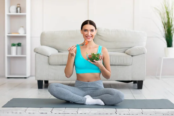 Тонка дівчина насолоджується здоровим овочевим салатом втрачаючи вагу вдома — стокове фото
