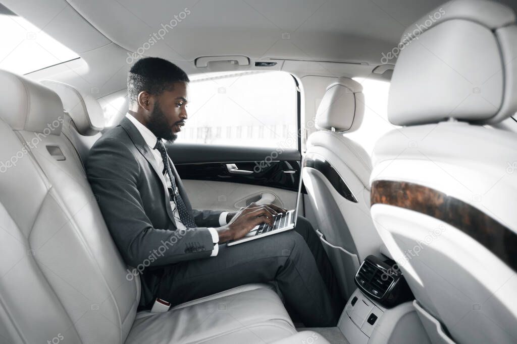 African American Businessman Working On Laptop Sitting In Car