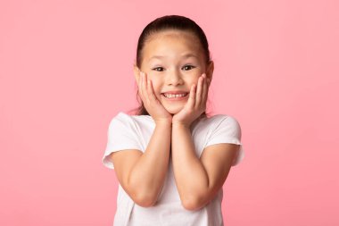 Stüdyoda yanaklara dokunan Asyalı kız heyecanlanıyor.