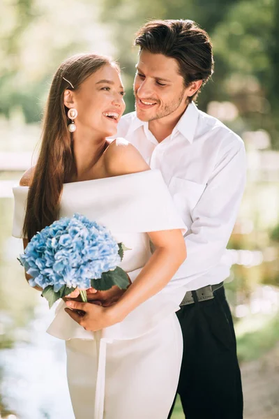 Liebevolle Umarmung von Braut und Bräutigam im Park während der Hochzeitszeremonie — Stockfoto