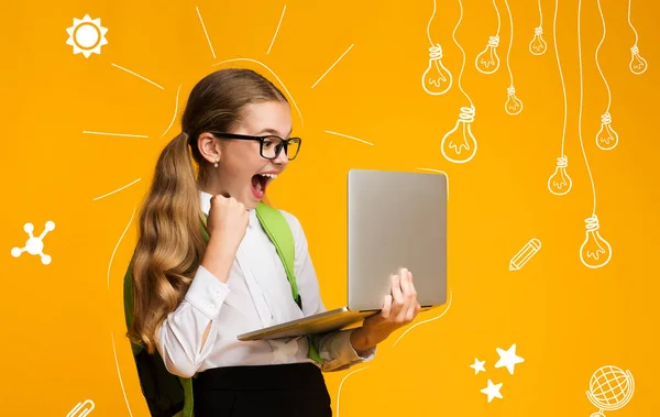 Moderne opvoeding van kinderen. Overhappy schoolmeisje met rugzak is blij met het testresultaat, houdt laptop — Stockfoto