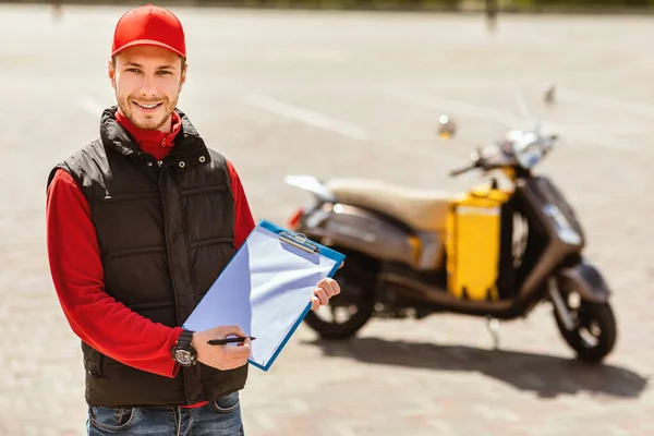 Delivery Man in Uniform Holding mappa Álló közelében Motorkerékpár Kültéri — Stock Fotó